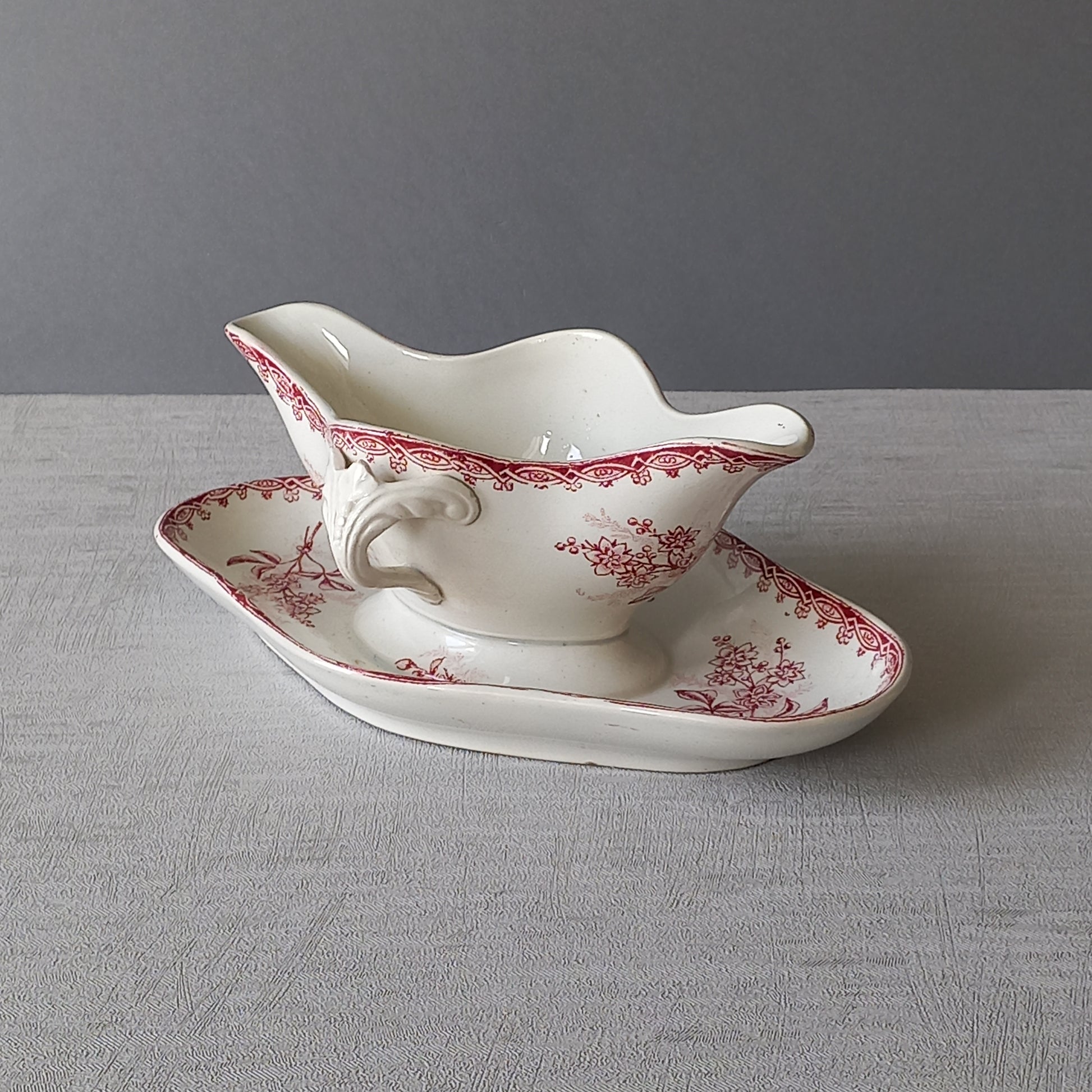 A French antique ironstone gravy boat with a pretty pink floral transfer pattern, a heavy and quality piece manufactured by St. Amand,circa. early 20th century.