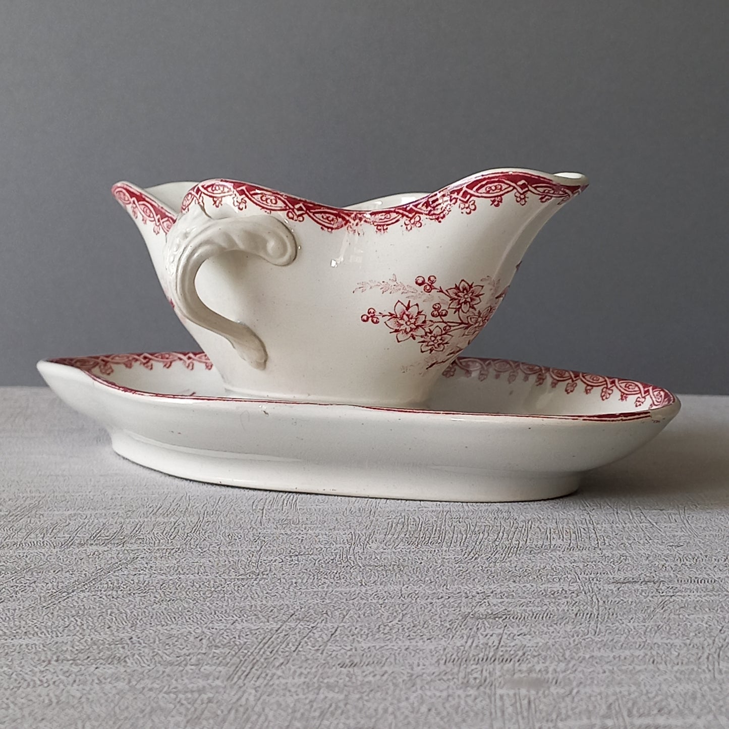 A French antique ironstone gravy boat with a pretty pink floral transfer pattern, a heavy and quality piece manufactured by St. Amand,circa. early 20th century.