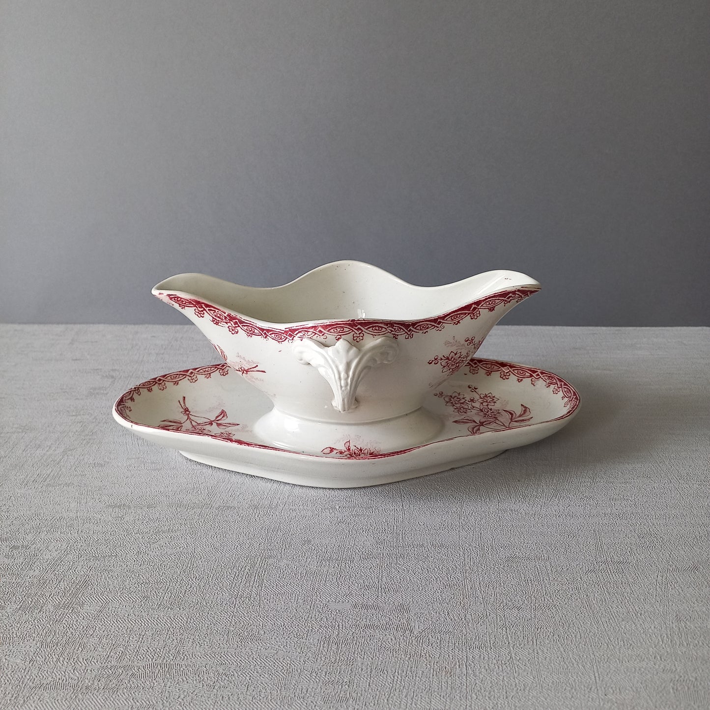 A French antique ironstone gravy boat with a pretty pink floral transfer pattern, a heavy and quality piece manufactured by St. Amand,circa. early 20th century.