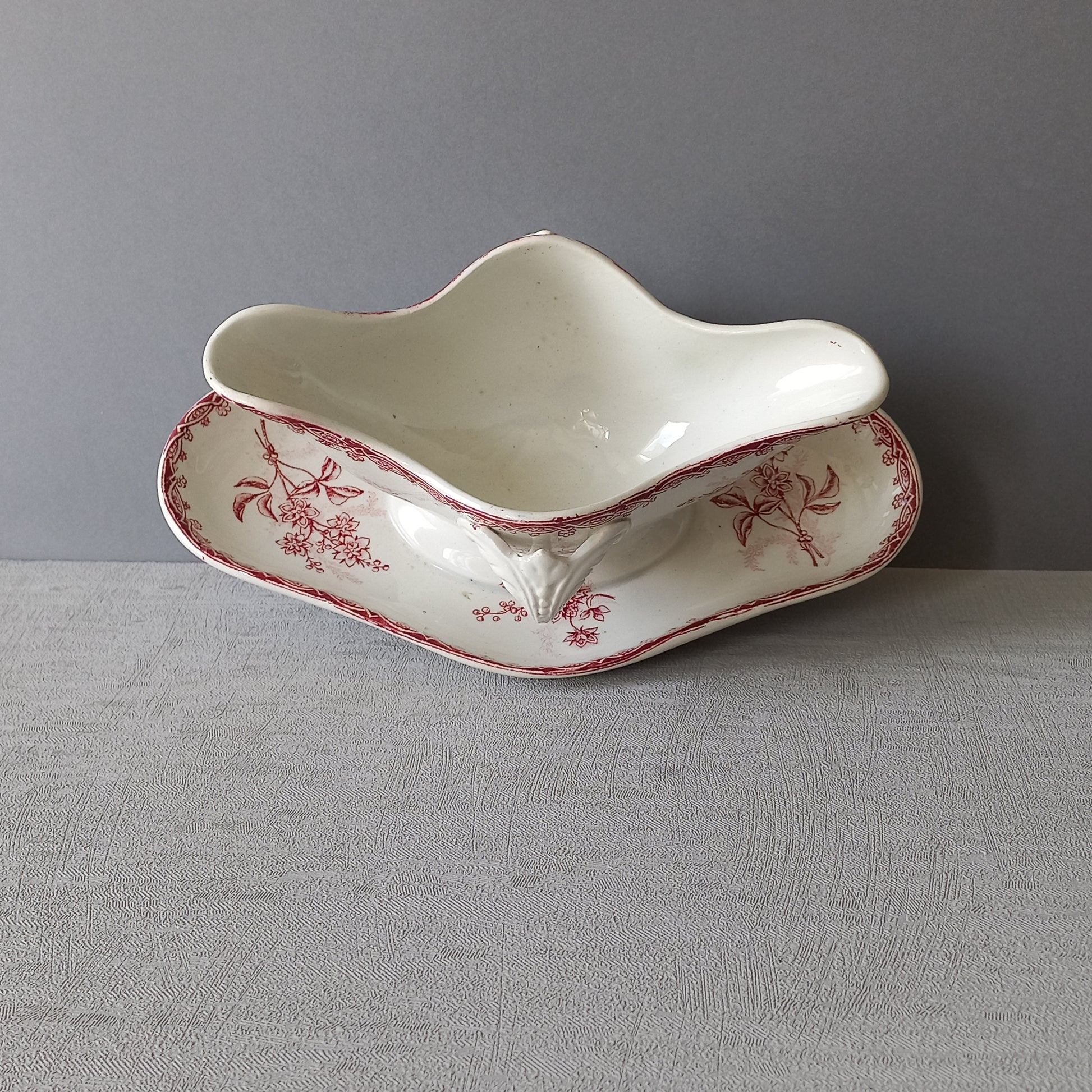 A French antique ironstone gravy boat with a pretty pink floral transfer pattern, a heavy and quality piece manufactured by St. Amand,circa. early 20th century.