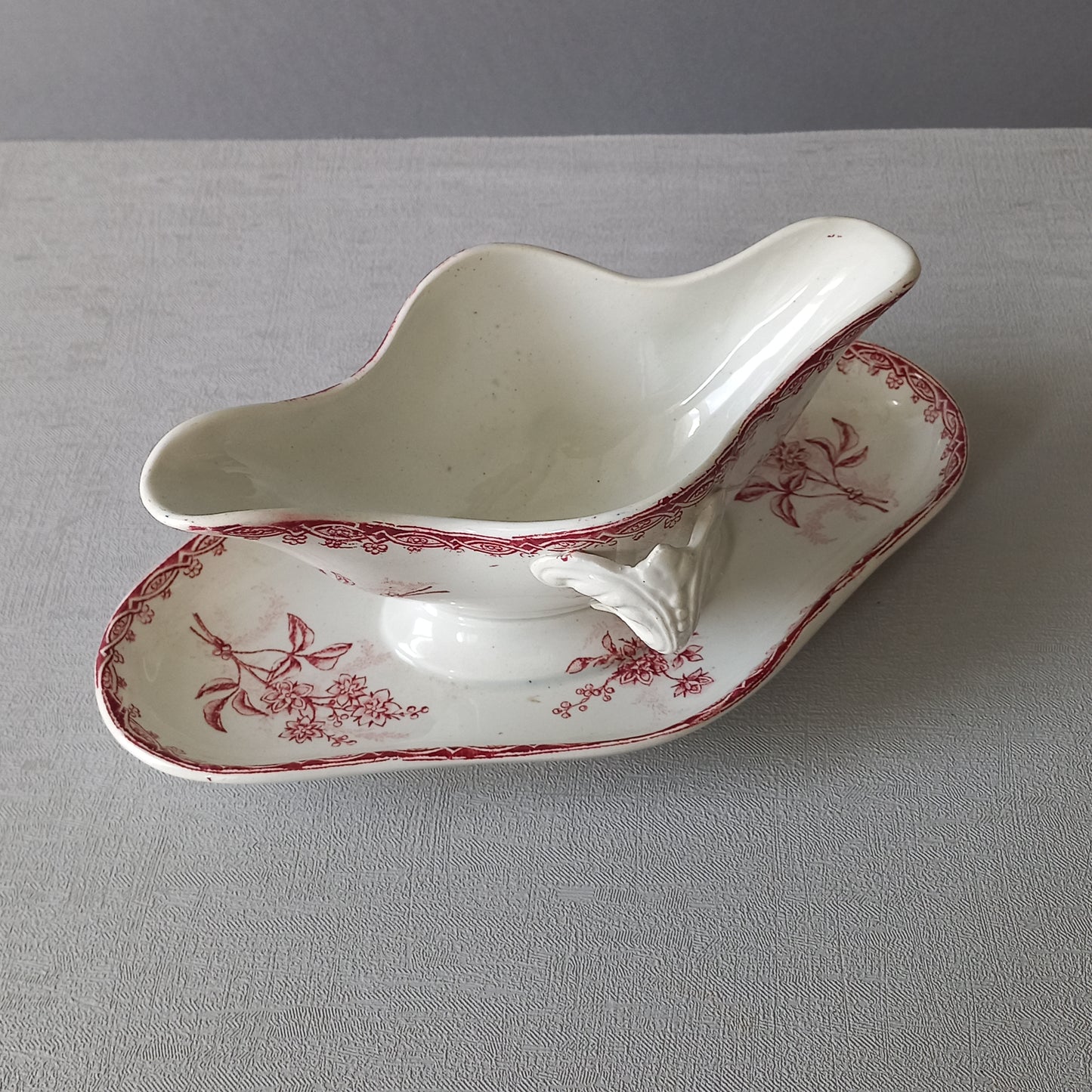 A French antique ironstone gravy boat with a pretty pink floral transfer pattern, a heavy and quality piece manufactured by St. Amand,circa. early 20th century.