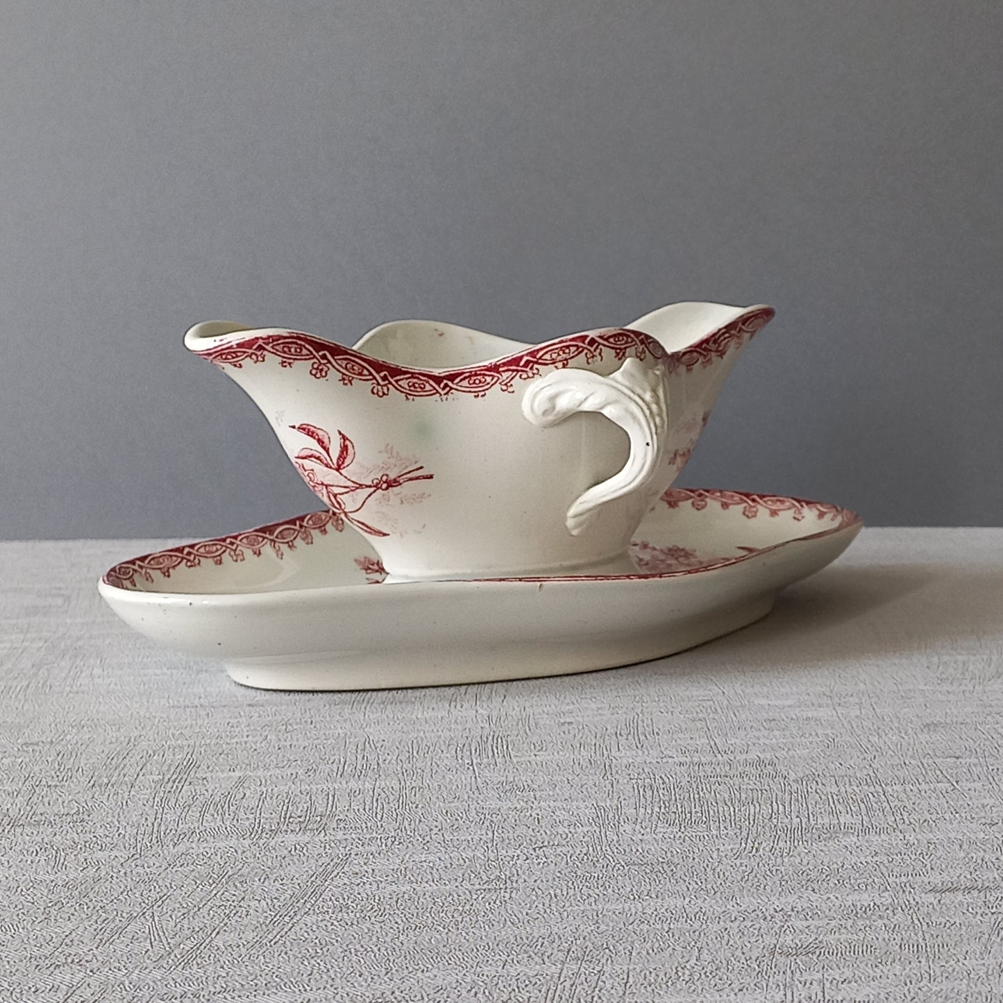 A French antique ironstone gravy boat with a pretty pink floral transfer pattern, a heavy and quality piece manufactured by St. Amand,circa. early 20th century.