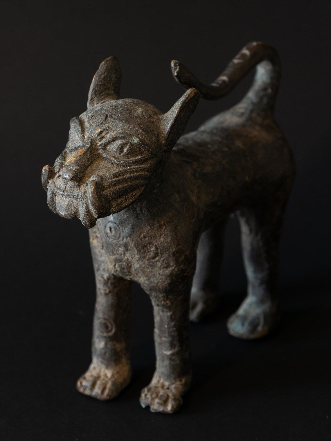 Bronze figurine of a creature with a dark background