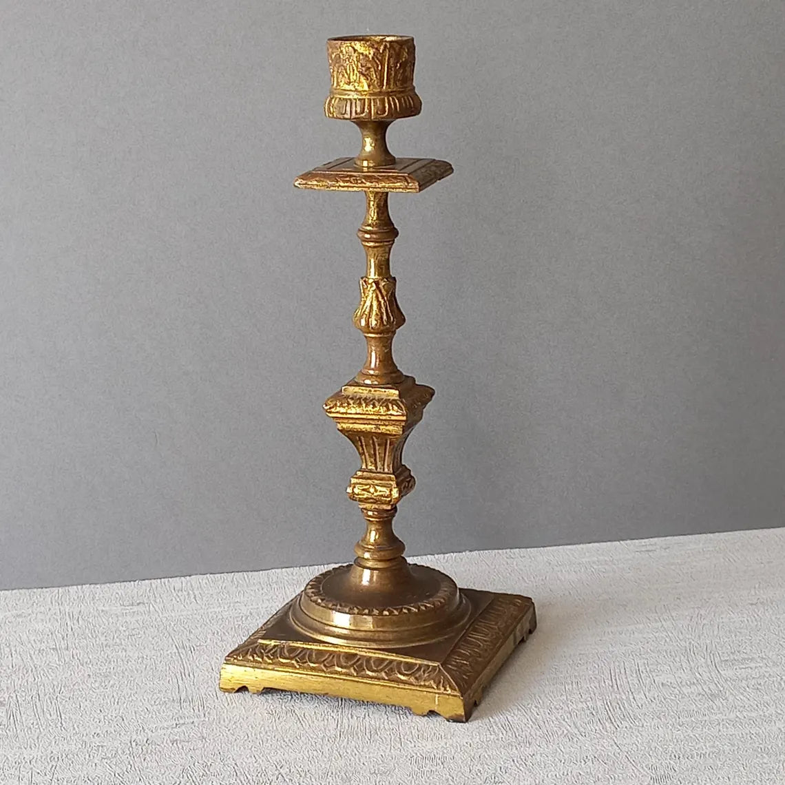Decorative bronze candlestick on a gray background