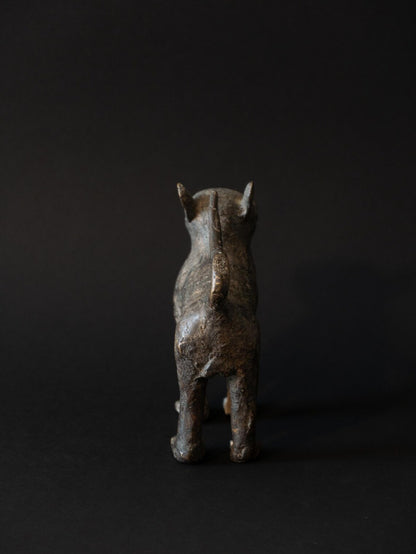 Bronze cat figurine on a black background
