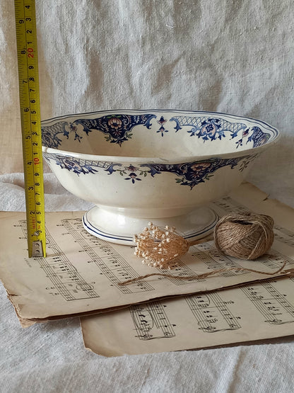 Large French antique decorative footed bowl with a stunning floral pattern in a decorative setting  with a tape measure for reference.