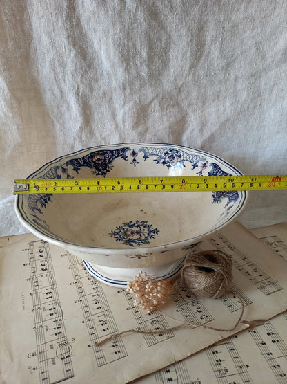 Large French antique decorative footed bowl with a stunning floral pattern in a decorative setting  with a tape measure for reference.