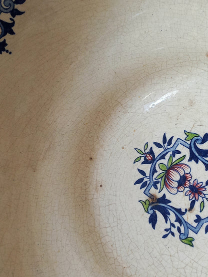 Close-up of a large French antique decorative footed bowl with a stunning floral pattern in a decorative setting .
