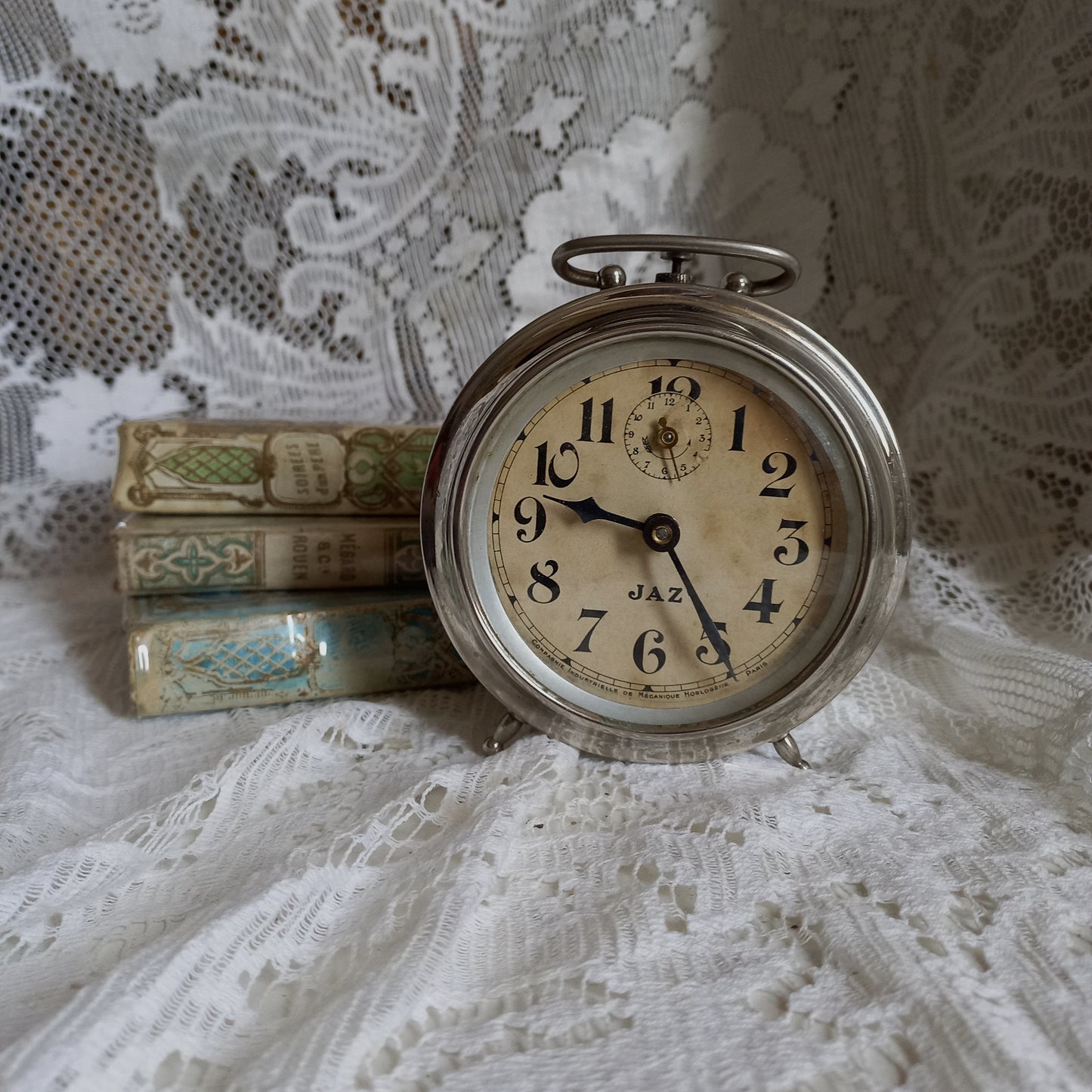 Small vintage mechanical alarm clock by French company Jaz with silver colored, chrome case