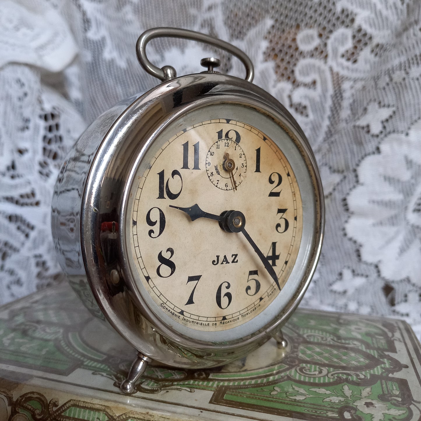 Small vintage mechanical alarm clock by French company Jaz with silver colored, chrome case