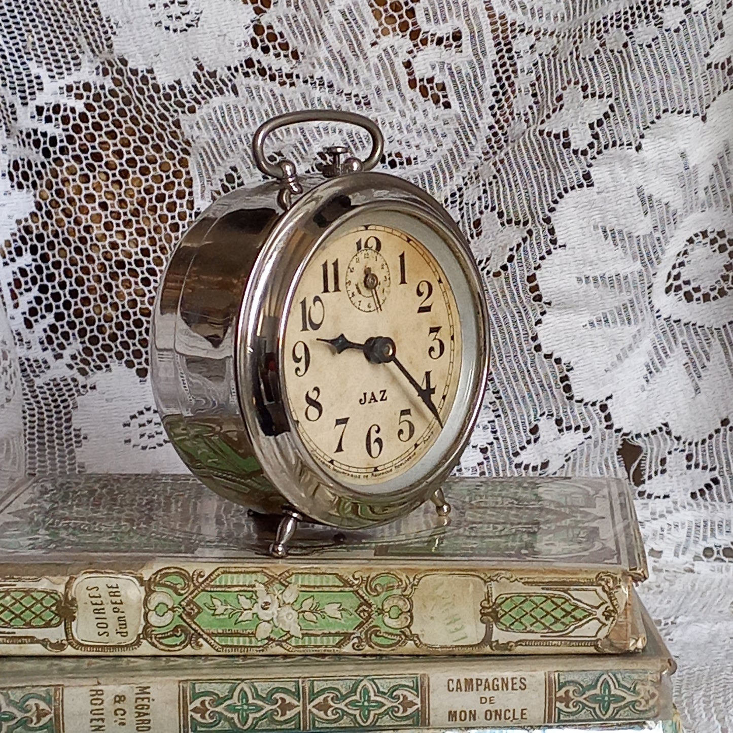 Small vintage mechanical alarm clock by French company Jaz with silver colored, chrome case