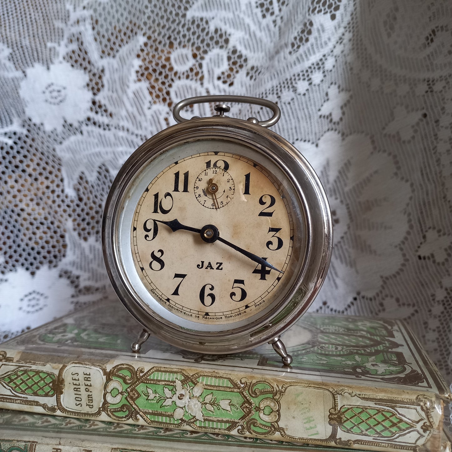 Small vintage mechanical alarm clock by French company Jaz with silver colored, chrome case