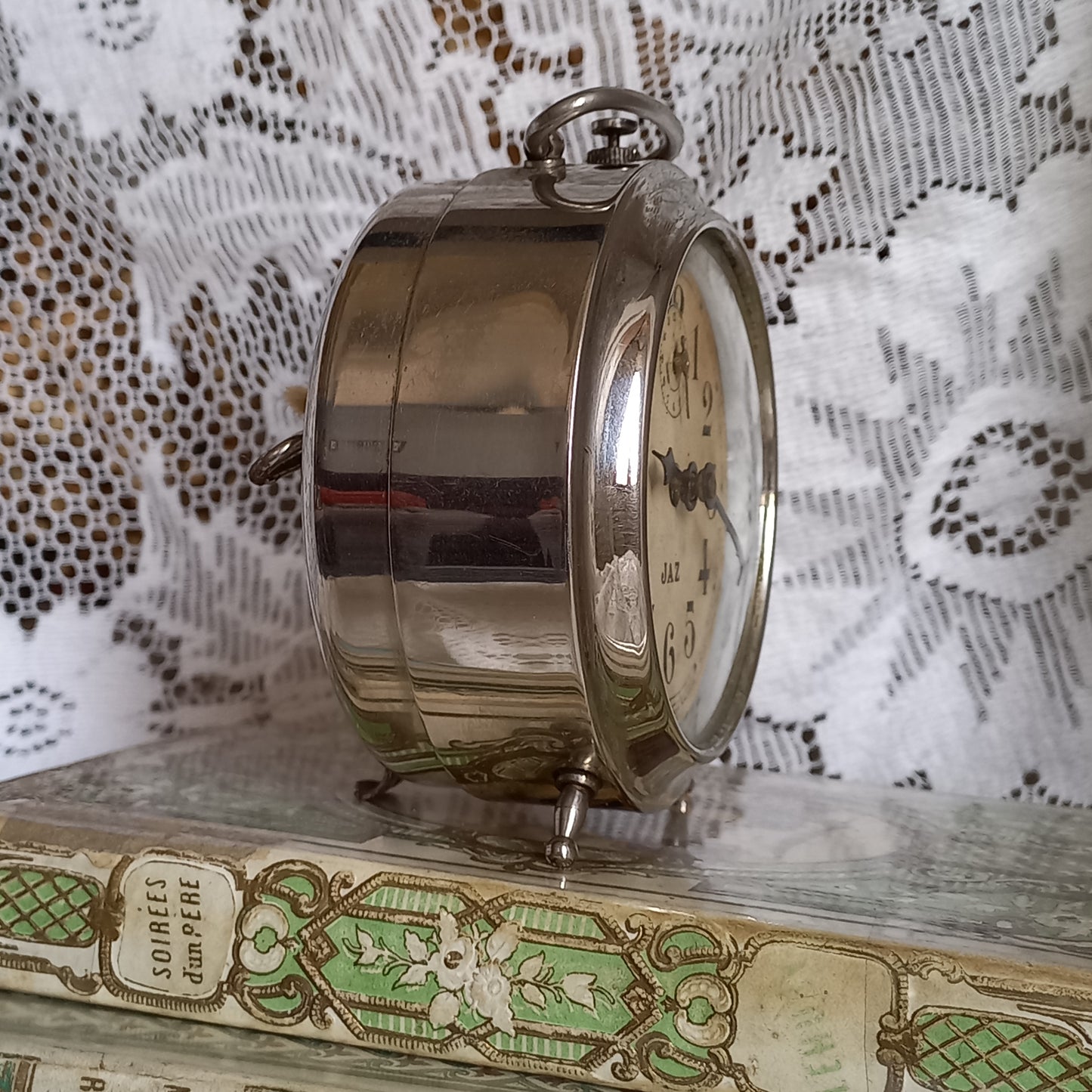 Small vintage mechanical alarm clock by French company Jaz with silver colored, chrome case