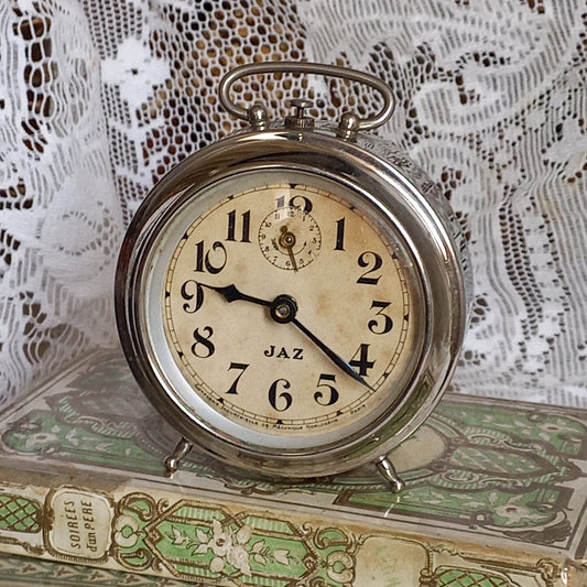 Small vintage mechanical alarm clock by French company Jaz with silver colored, chrome case