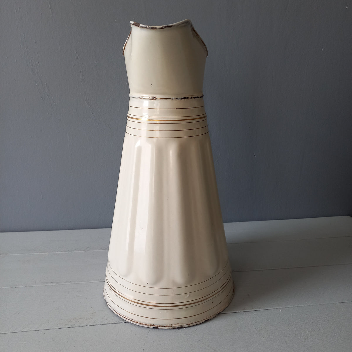 Large antique enamel metal pitcher in cream color with gold trim from France