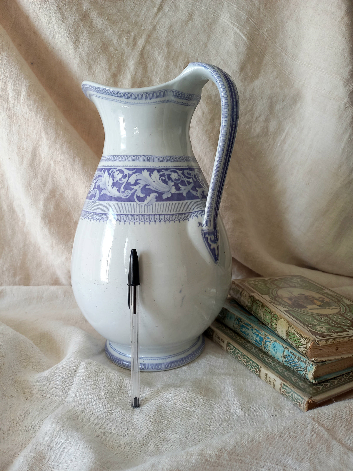 antique ironstone pitcher in white with a rare lavender colour decorative pattern in a decorative setting.