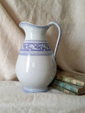 Antique ironstone pitcher in white with a rare lavender colour decorative pattern in a decorative setting.