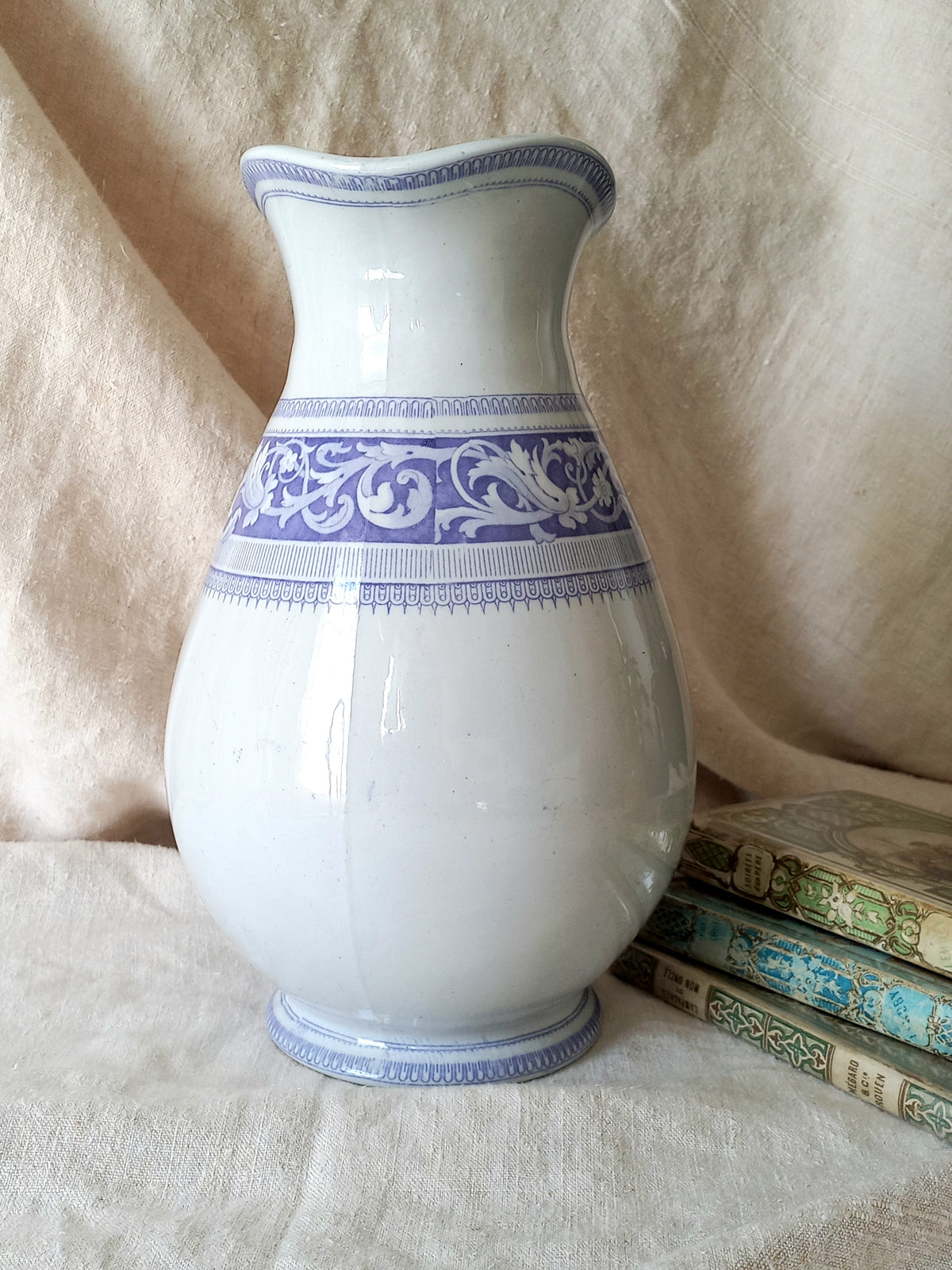 Antique ironstone pitcher in white with a rare lavender colour decorative pattern in a decorative setting.