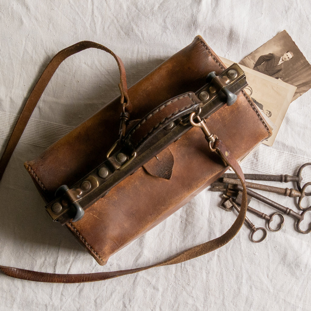 A French vintage leather shoulder/hand bag that's both practical and perfect as a prop or decorative piece in your interior, a beautifully aged piece with just enough patina of age to give it that authentic character. We have polished the distressed leather and thoroughly cleaned the bag both inside and out.