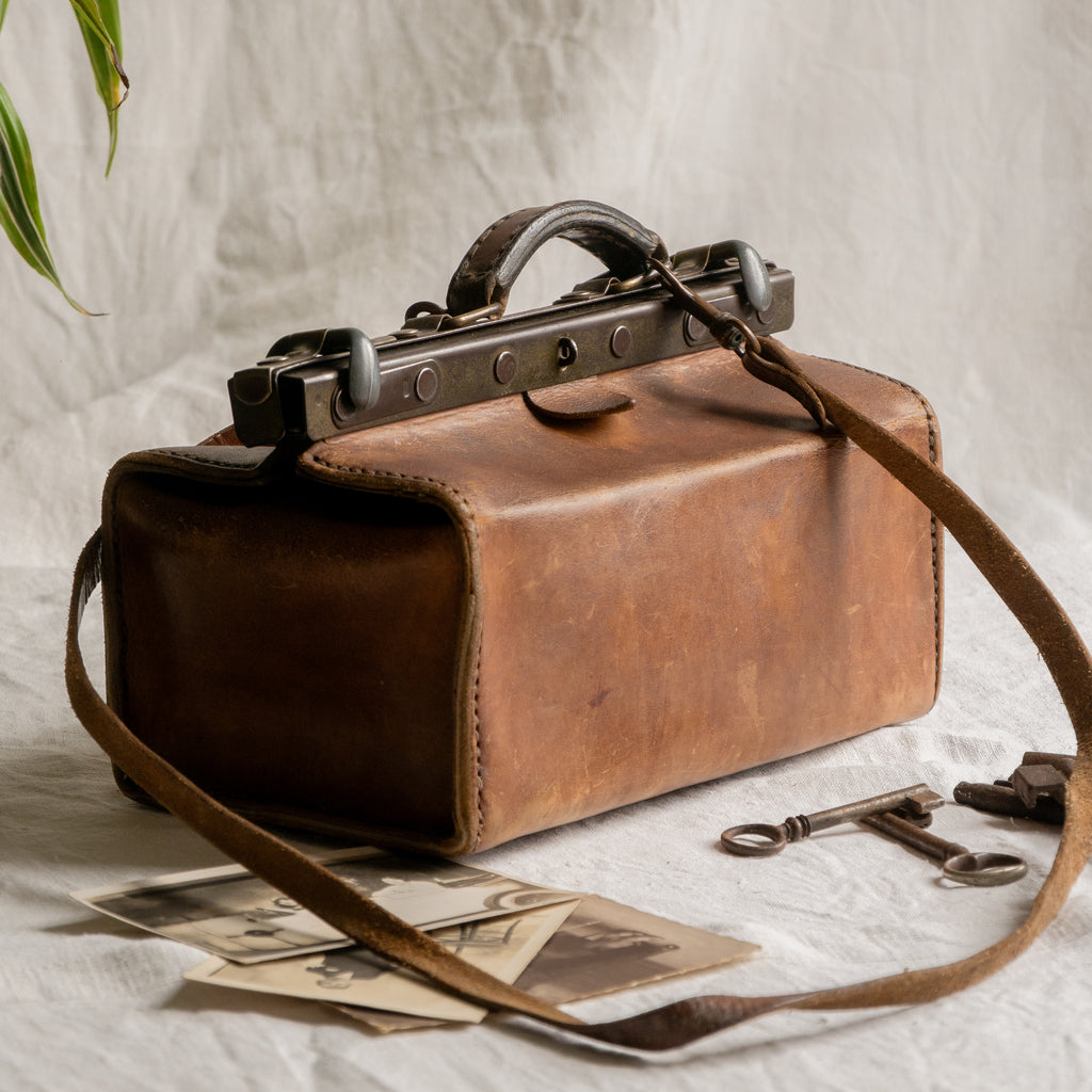 A French vintage leather shoulder/hand bag that's both practical and perfect as a prop or decorative piece in your interior, a beautifully aged piece with just enough patina of age to give it that authentic character. We have polished the distressed leather and thoroughly cleaned the bag both inside and out.