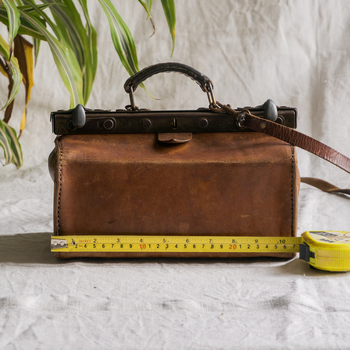 A French vintage leather shoulder/hand bag that's both practical and perfect as a prop or decorative piece in your interior, a beautifully aged piece with just enough patina of age to give it that authentic character. We have polished the distressed leather and thoroughly cleaned the bag both inside and out.