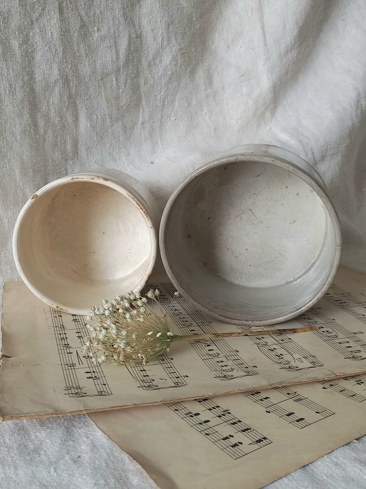 Two ceramic bowls on an old sheet of music with a light background