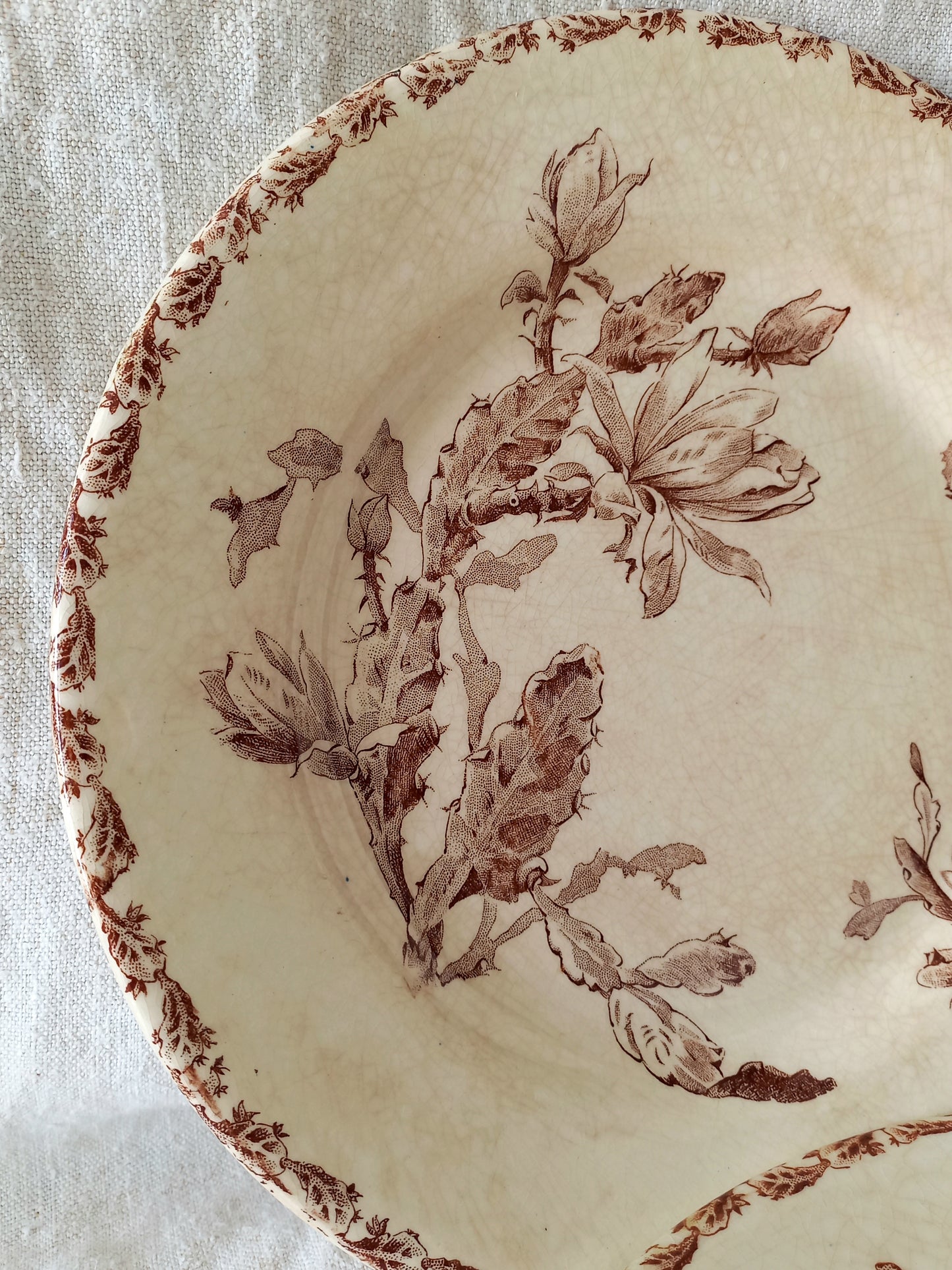 Decorative plate with brown floral pattern on a textured beige background