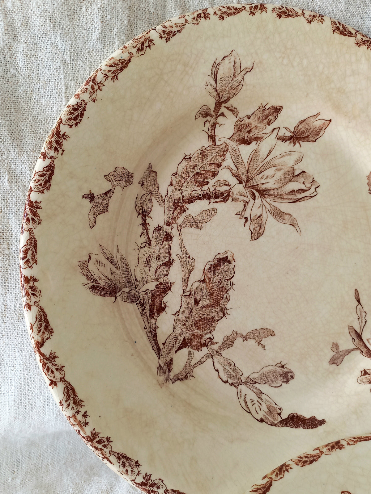Decorative plate with brown floral pattern on a textured beige background