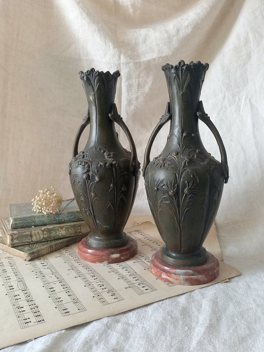 A stunning pair of decorative art nouveau vase/urn ornaments made from metal and finished in a stunning shade of green depicting organic floral decoration in relief.