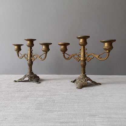 A pair of small vintage antique metal candelabras. This pair of decorative candle stick holders will give that touch of French shabby chic to any interior.