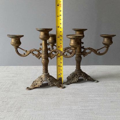 A pair of small vintage antique metal candelabras. This pair of decorative candle stick holders will give that touch of French shabby chic to any interior.