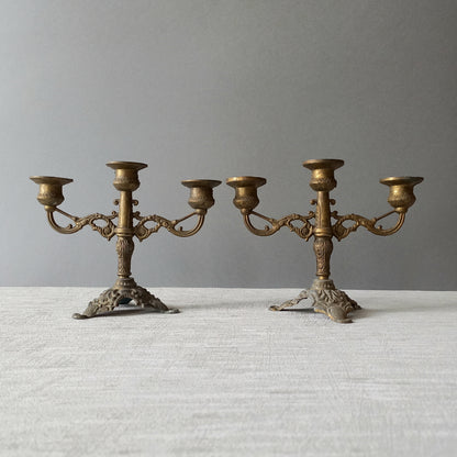 A pair of small vintage antique metal candelabras. This pair of decorative candle stick holders will give that touch of French shabby chic to any interior.