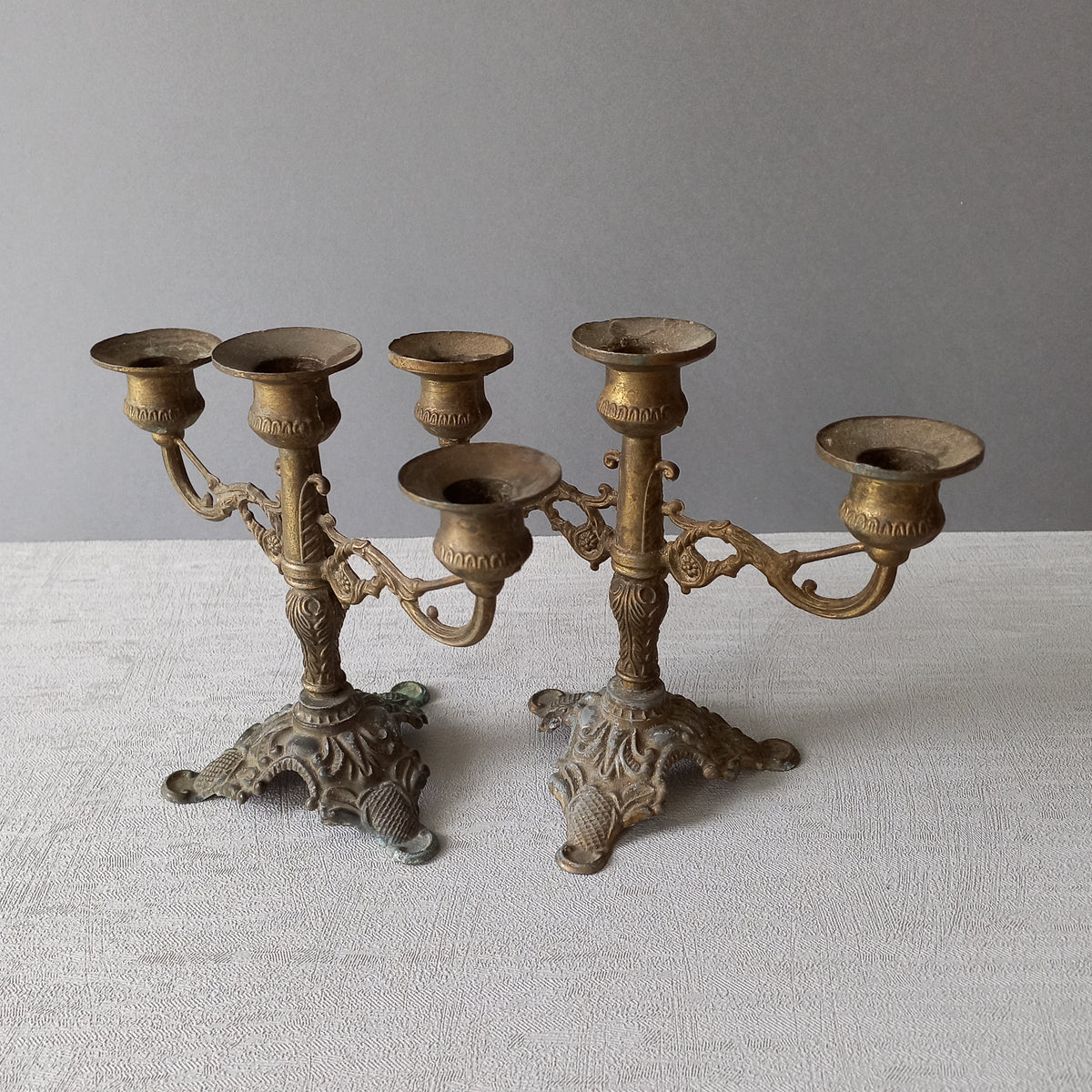 A pair of small vintage antique metal candelabras. This pair of decorative candle stick holders will give that touch of French shabby chic to any interior.