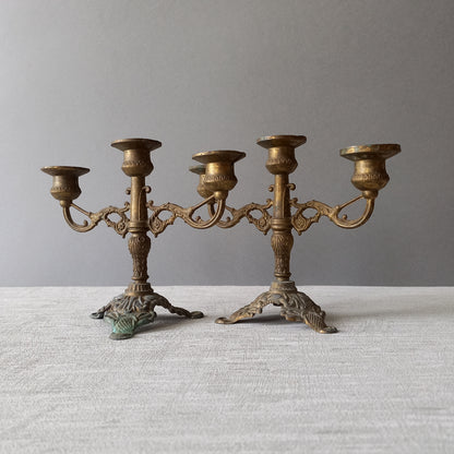 A pair of small vintage antique metal candelabras. This pair of decorative candle stick holders will give that touch of French shabby chic to any interior.