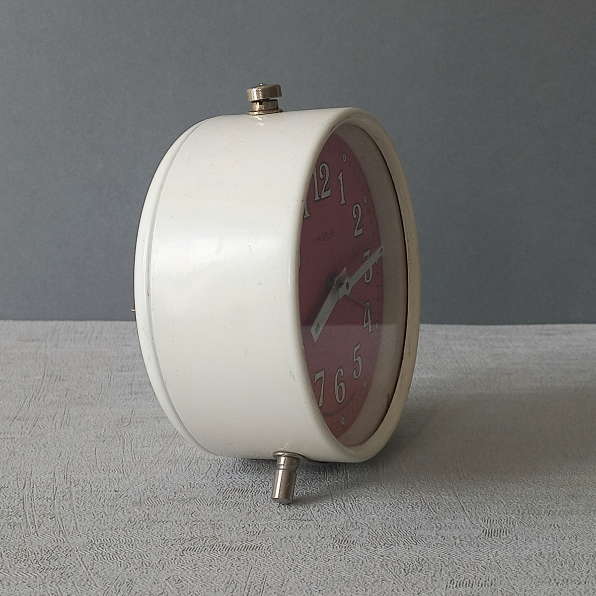 A wonderful vintage alarm clock in an eye-catching white and pink color scheme. This old clock is in working condition including the alarm and has a nice soothing ticking sound too. A great piece of European history from the former country of Czechoslovakia.