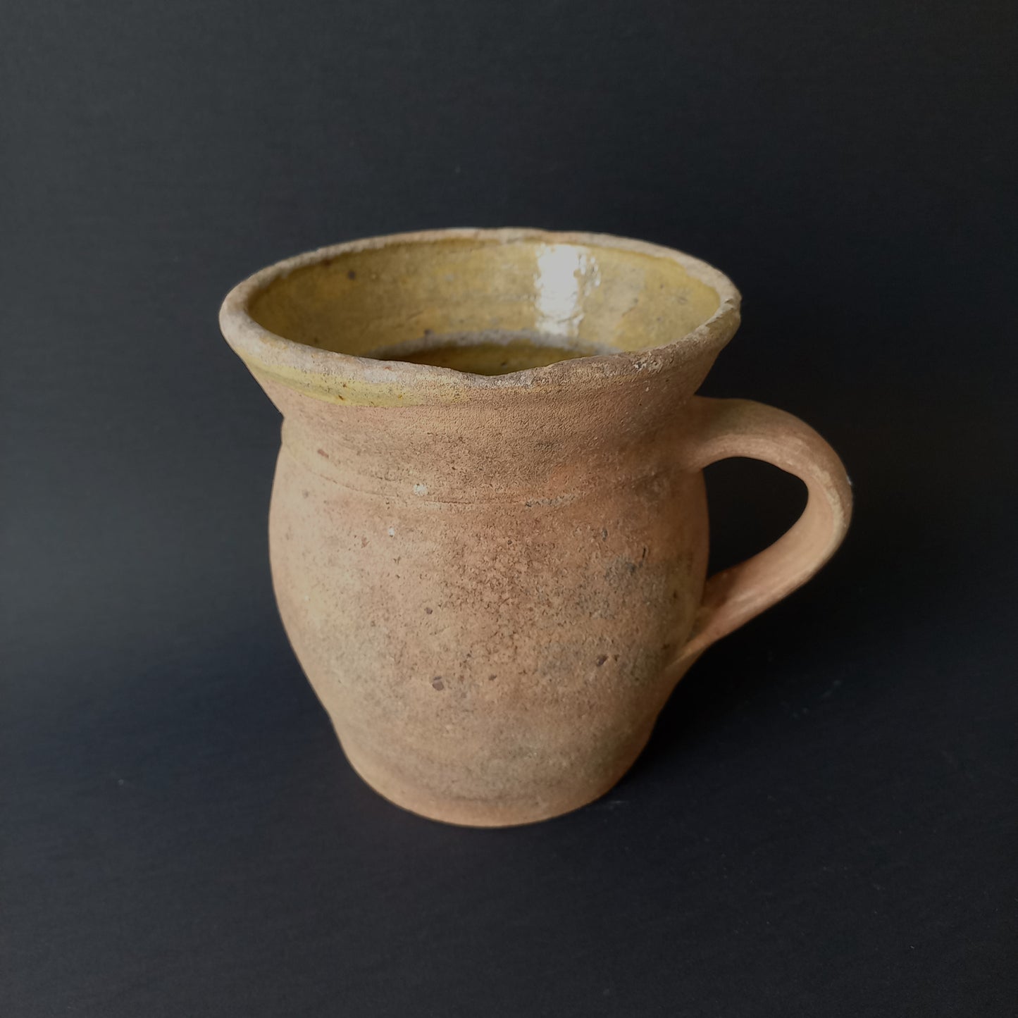 Small rustic vintage pottery jug with ochre glazed interior from France