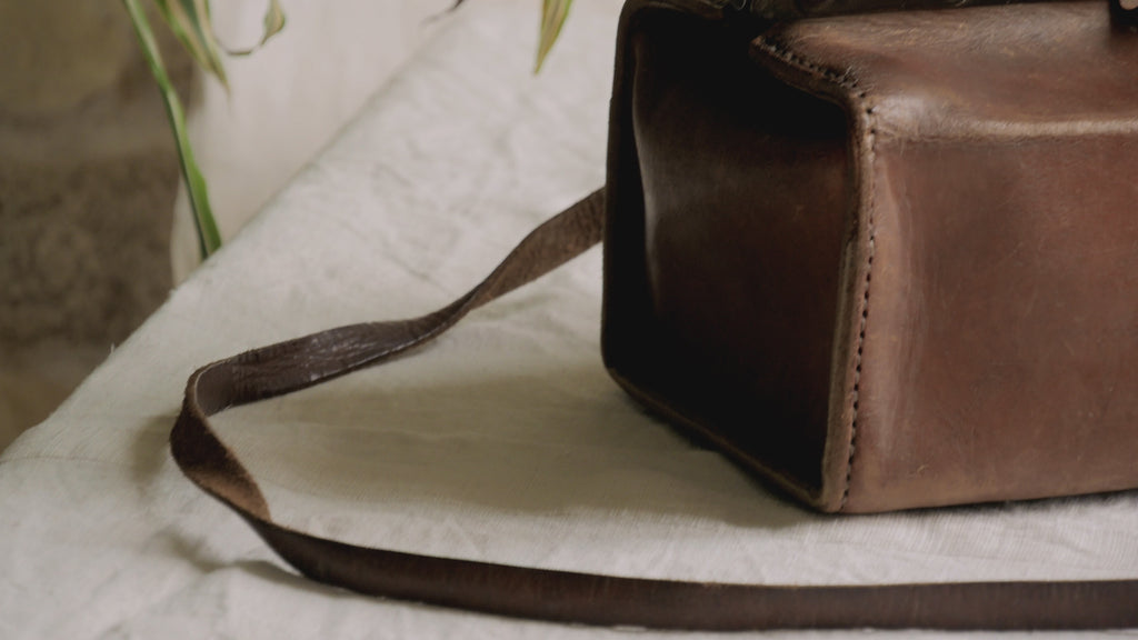 A French vintage leather shoulder/hand bag that's both practical and perfect as a prop or decorative piece in your interior, a beautifully aged piece with just enough patina of age to give it that authentic character. We have polished the distressed leather and thoroughly cleaned the bag both inside and out.