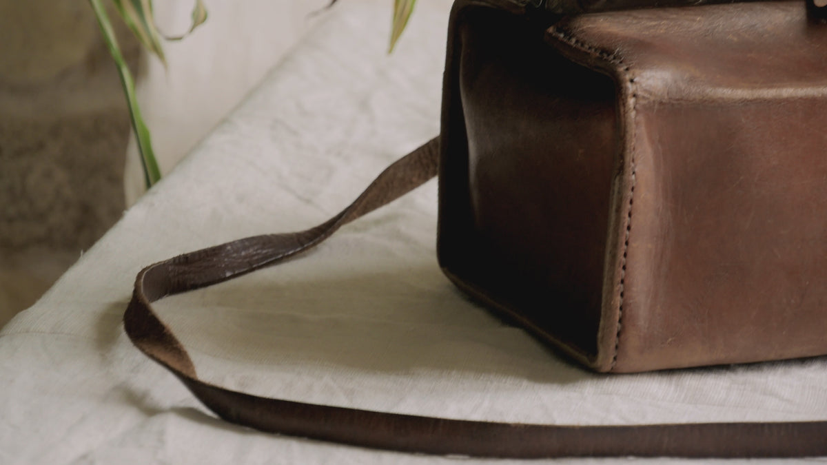 A French vintage leather shoulder/hand bag that's both practical and perfect as a prop or decorative piece in your interior, a beautifully aged piece with just enough patina of age to give it that authentic character. We have polished the distressed leather and thoroughly cleaned the bag both inside and out.