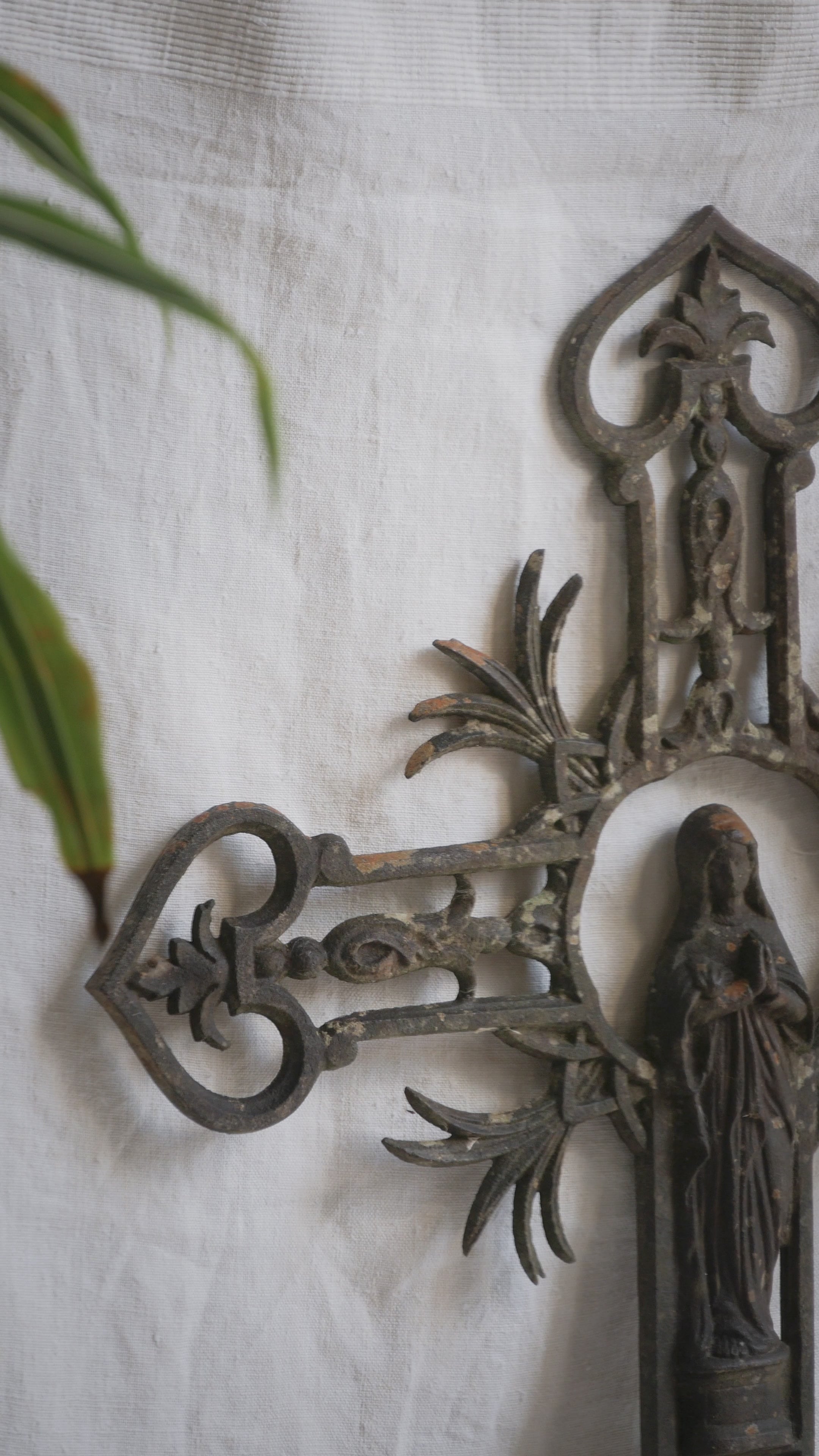 A large French antique crucifix in cast or wrought iron, featuring a figure of the Madonna at its center. Likely once part of a larger architectural structure, this rare piece carries visible signs of age and long exposure to the elements.