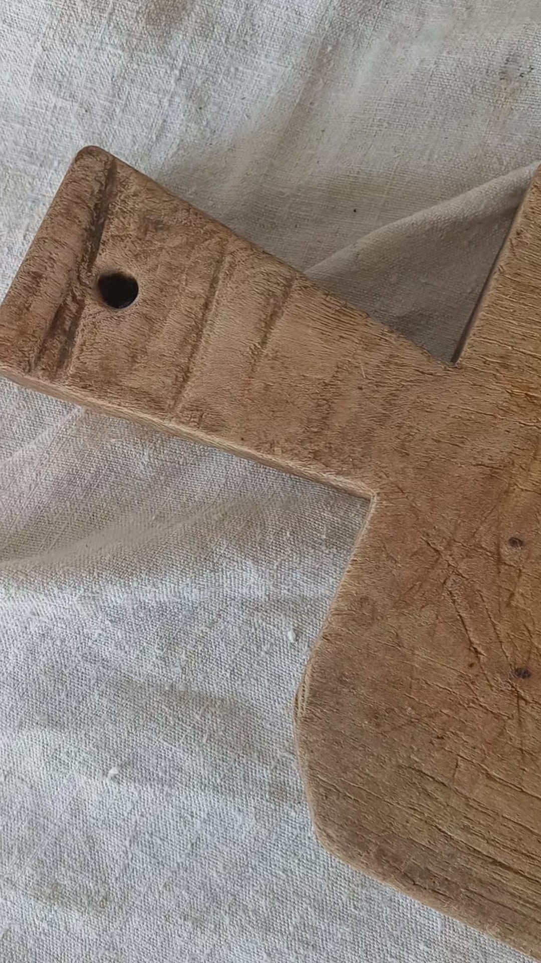 Antique French chunky hand-carved wooden cutting board in a rustic setting.
