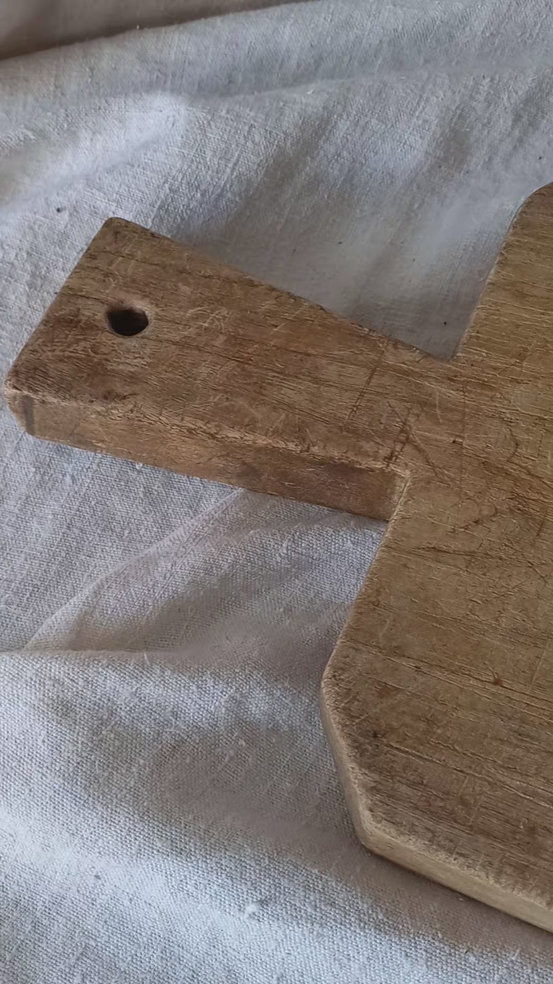 Antique French chunky hand-carved wooden cutting board in a rustic setting.