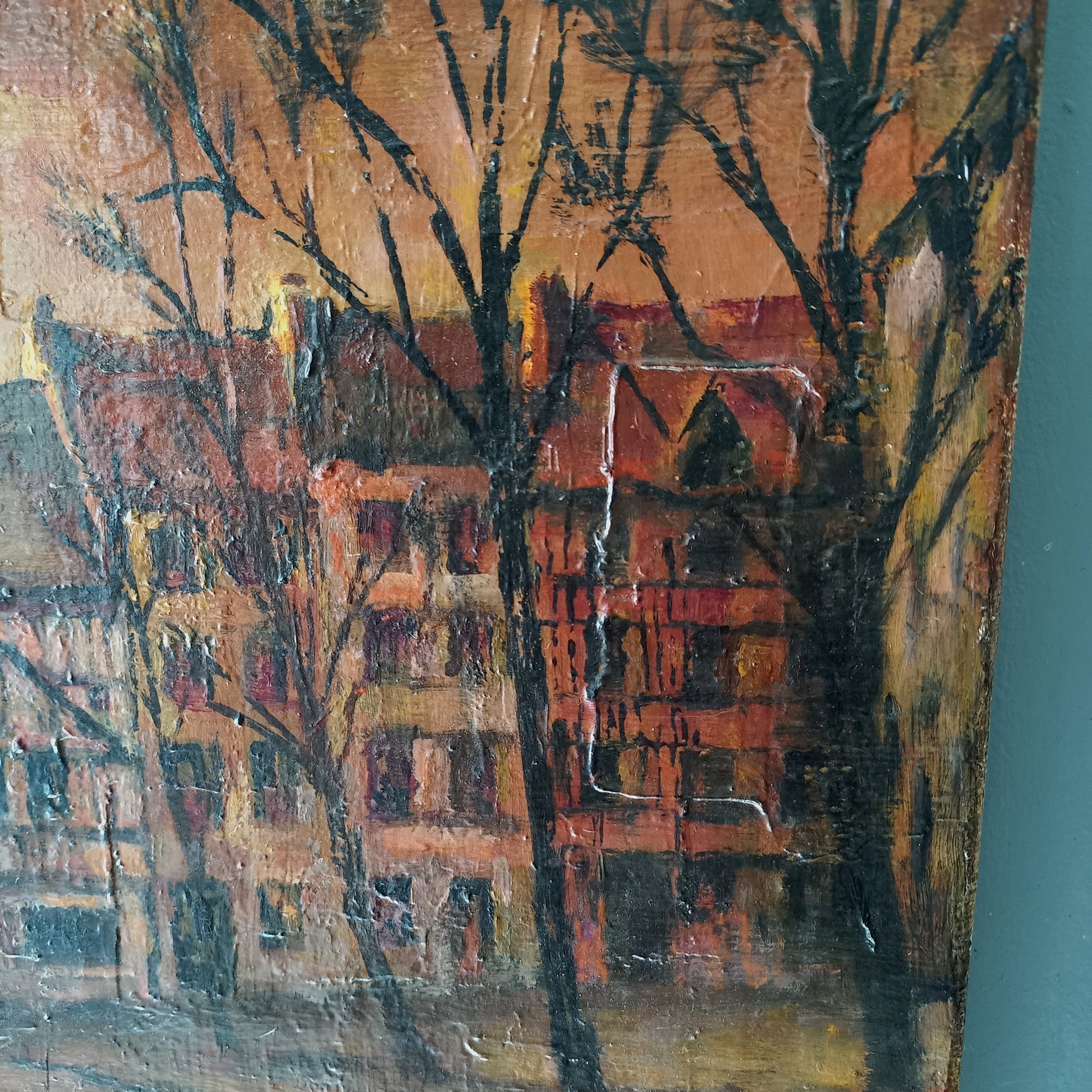 Painting of a cityscape with buildings and trees on a textured surface.