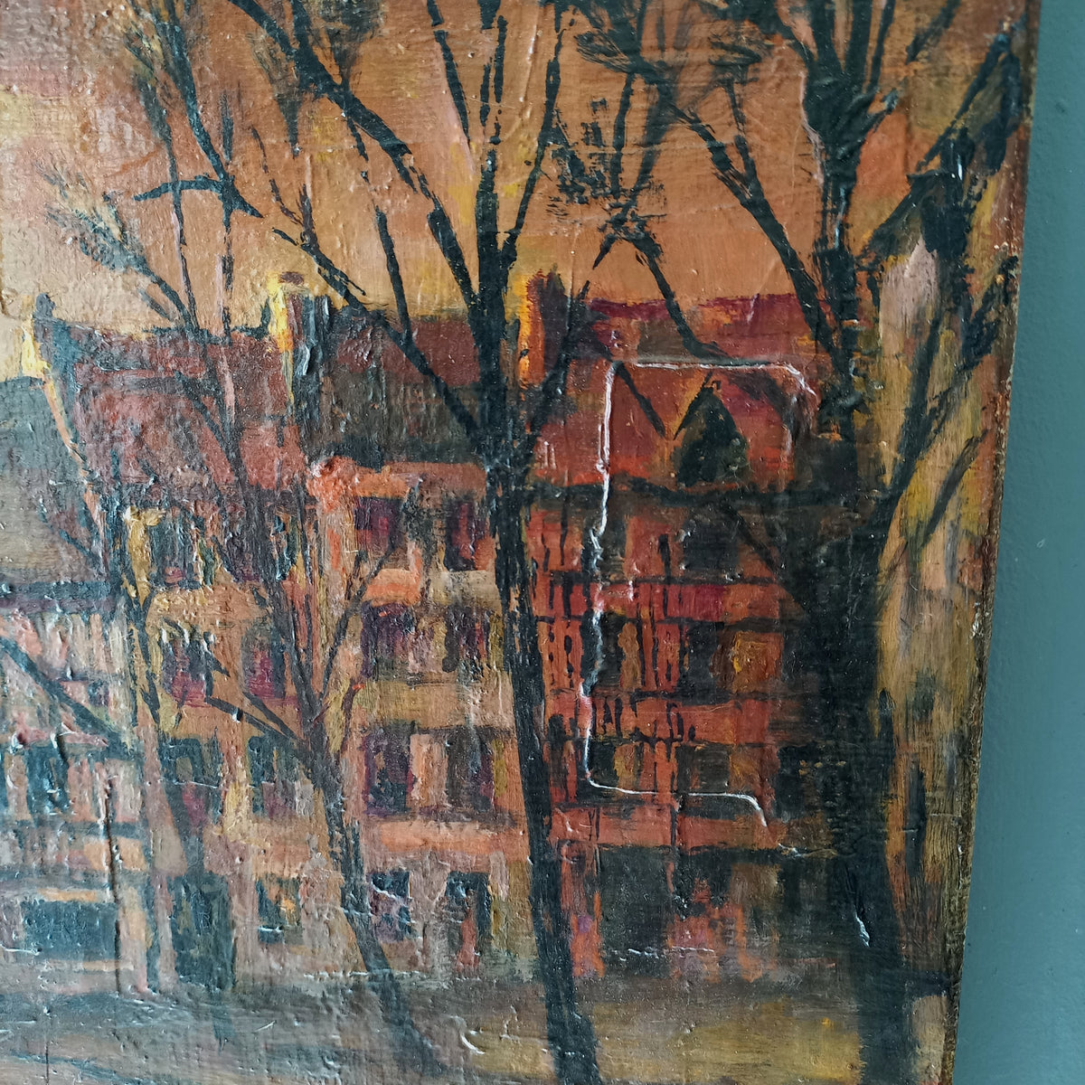 Painting of a cityscape with buildings and trees on a textured surface.