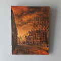Painting of a street scene with buildings and trees on a gray wall