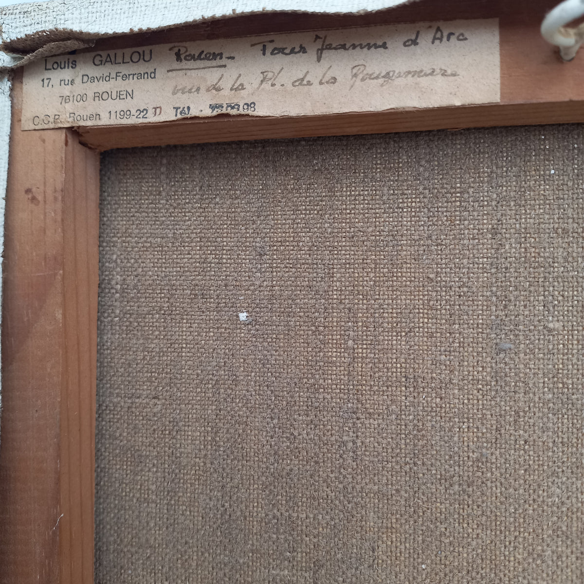 Back of a painting with artist's signature and contact information