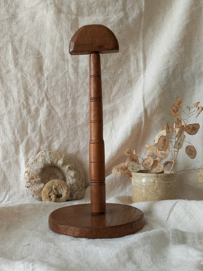 vintage wooden hat stand on a textured white fabric background