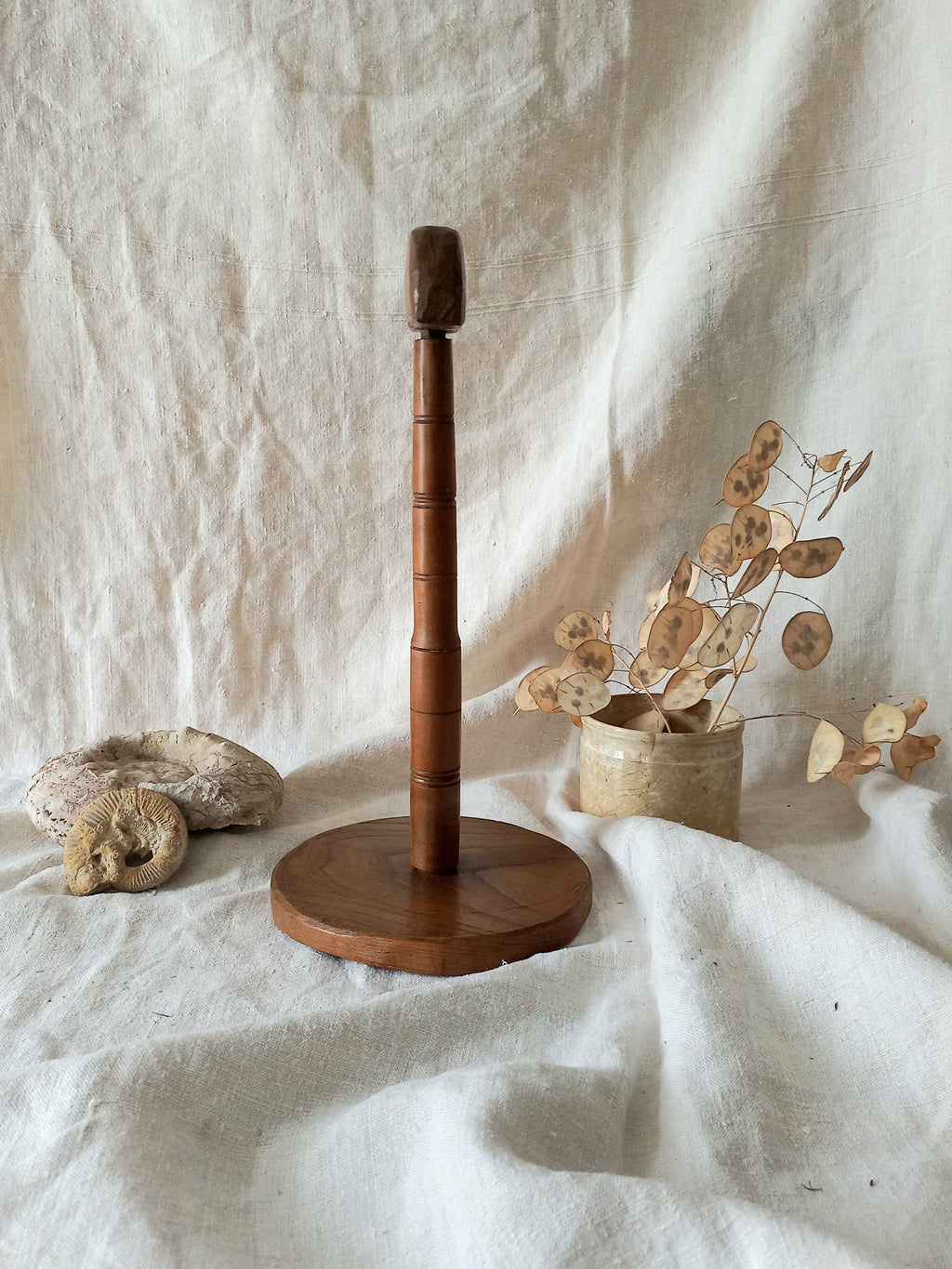 vintage wooden hat stand on a textured white fabric background