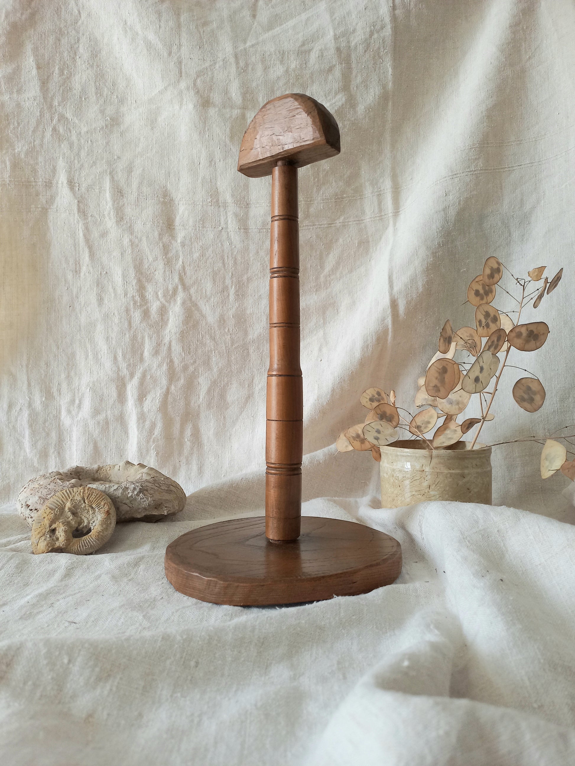 vintage wooden hat stand on a textured white fabric background