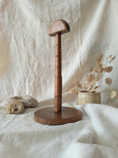 vintage wooden hat stand on a textured white fabric background