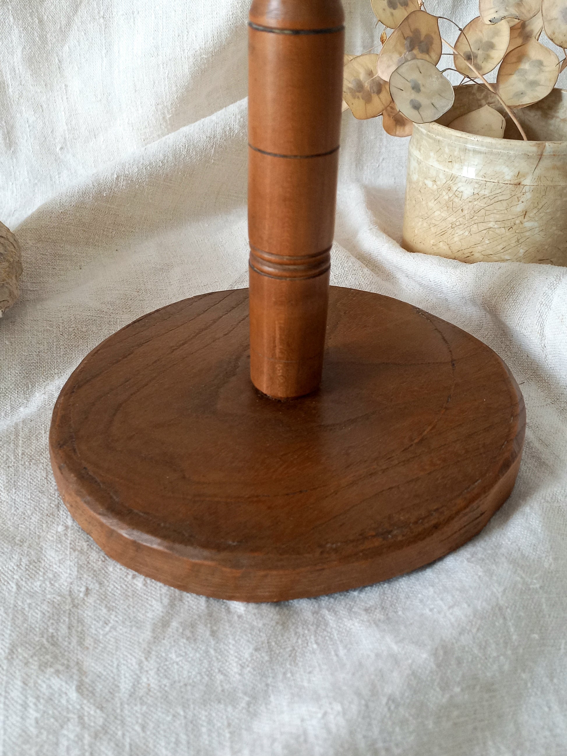 vintage wooden hat stand on a textured white fabric background